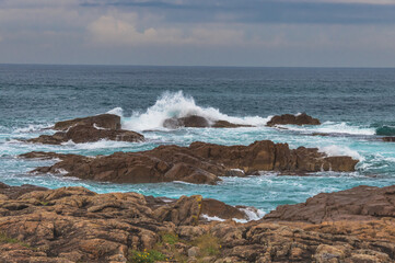 Rocky Seascape with Blue Aquamarine Sea and Earthy Brown Rocks