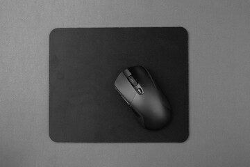 Black wireless mouse on a mouse pad.