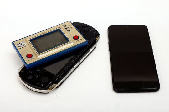 Old and classic game console and a touchscreen smartphone isolated on white background