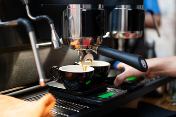 Fototapeta na wymiar A barista in a coffee machine makes coffee