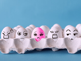 The odd one, Faces on the eggs, no to racism, discrimination concept with blue background