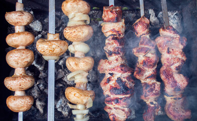 mushrooms and meat on skewers are cooked on coals.barbecue.health food .close up