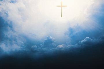 Christian cross appears bright in cloudy dark sky background