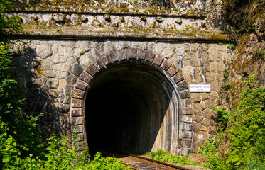 Ancient tunnel portal of the Schiltach Tunnel in the city of Schiltach, Germany. The tunnel is very narrow so that only one railroad is leading through.