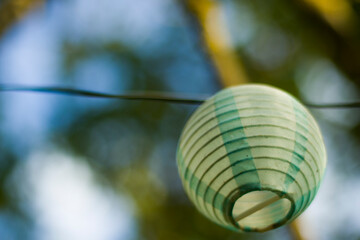 Fototapeta premium Lantern in the yard on the tree bokeh background, night and warm light, hanging lanterns.