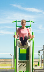 Active woman exercising on leg raise outdoor.