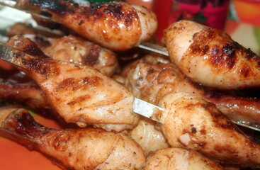 Charcoal-fried chicken shins strung on skewers closeup