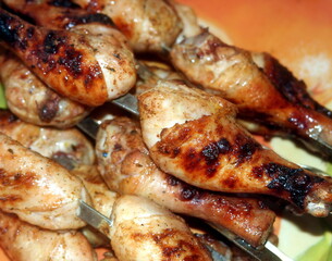 Charcoal-fried chicken shins strung on skewers closeup