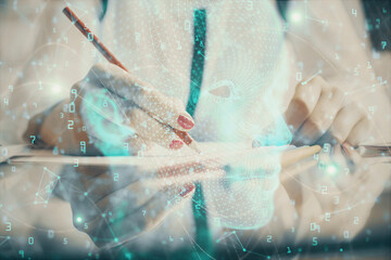 Multi exposure of woman's writing hand on background with brain hud. Concept of learning.