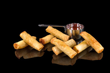 Delicious spring rolls with vegetables or meat  with reflection, isolated on black background