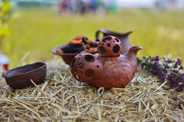 Clay teapot for tea and clay pottery in the hay