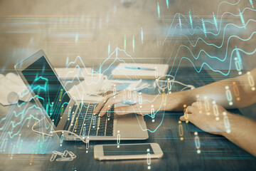 Double exposure of forex chart with man working on computer on background. Concept of market...