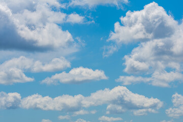 Obraz premium various shape fluffy cummulus clouds accumulating on blue summer sky 