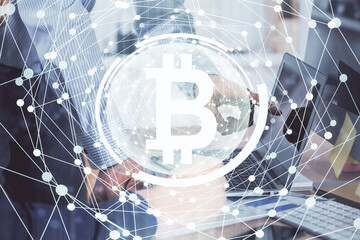 Crypto currency theme hologram with businessman working on computer on background. Concept of blockchain. Multi exposure.