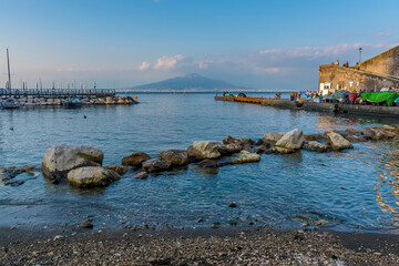 Fototapeta na wymiar Looking out from the beach in Marina Grande, Sorrento, Italy towards the Bay of Naples and Mount Vesuvius