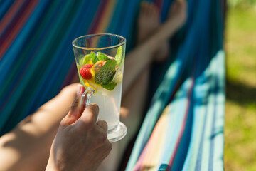 Fototapeta premium Woman with cocktail relaxed in hammock