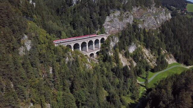Aerial view of passenger train rides on Krauselklause Viaduct on historical Semmering mountain railway (Semmeringbahn), Lower Austria.