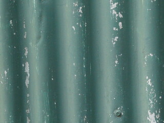 Galvanized corrugated metal wall background with chipped green paint
