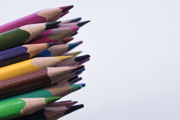 on the left, on a white background, a stack of colored pencils