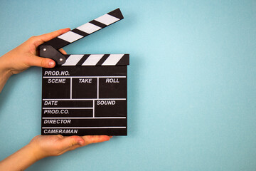 Obraz premium Klakier filmu na niebieskim tle, koncepcja kina