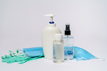 Fototapeta na wymiar bottle of lotion, sanitizer or liquid soap, rubber latex gloves and protective mask over light grey background