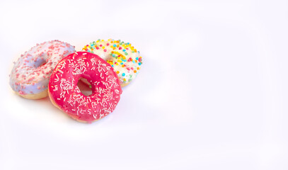 Three delicious and tempting donuts with different flavors and icing and colored sprinkles Isolated on a white background with copy space. Concept of unhealthy nutrition,sugar and sweet addiction.