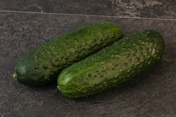 Green fresh cucumbers over background