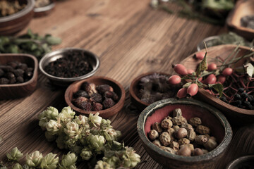 Large spice and herb collection in bowls and spoons forming an abstract background.