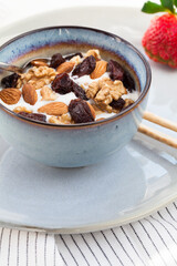 Greek type yoghurt with almons, walnuts, raisins and honey. Healthy vegetarian breakfast.