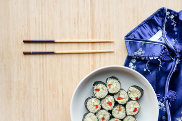Vegan sushi with chopsticks. Sushi from kinoa with bellpeper, avocado, cucumber