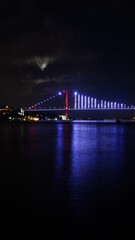 Fototapeta na wymiar Bosphorus bridge at night in Istanbul, navy blue sky and sea
