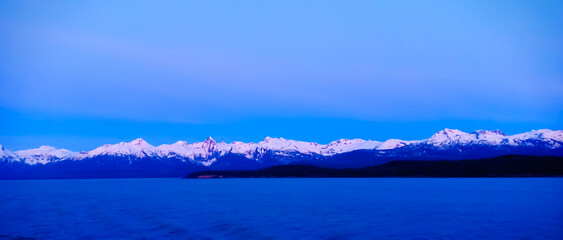 Snow covered mountain and blue ocean