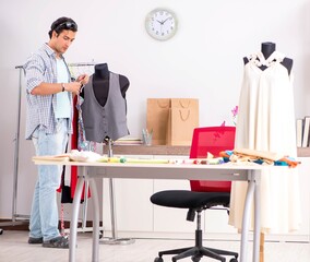 Young handsome tailor working in his workshop