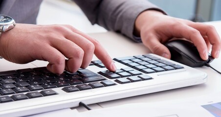 Finance professional working on keyboard with reports