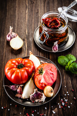 Raw tomatoes and sun dried tomatoes in olive in jar
