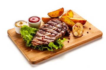 Grilled steak with baked potatoes and vegetables served on wooden board on white background
