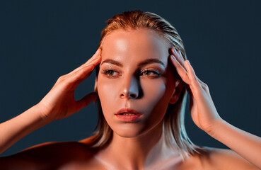 Fototapeta premium Beautiful Young Woman with Clean Fresh Skin touch own face . Facial treatment . Cosmetology , beauty and spa .