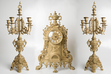Vintage gold watch with candelabra on white background, bronze clock and candelabra, gold candlesticks and clock, antique clock and candlesticks, vintage clock with chandeliers on a white background	
