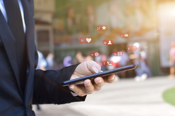 Close up of businessman using mobile smartphone with social media icons over blurred airport station background. Business, technology or social network concept.