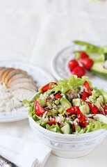 Salad with strawberries, quinoa, avocado, cucumber, lettuce, onions and green peas. vegetarian food. Summer unusual salad. Exquisite salad with strawberries. Healthy diet and diet.