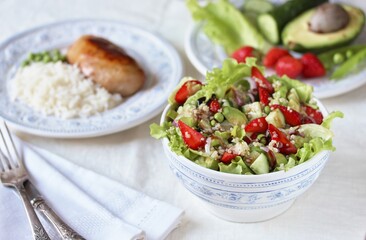 Salad with strawberries, quinoa, avocado, cucumber, lettuce, onions and green peas. vegetarian food. Summer unusual salad. Exquisite salad with strawberries. Healthy diet and diet.