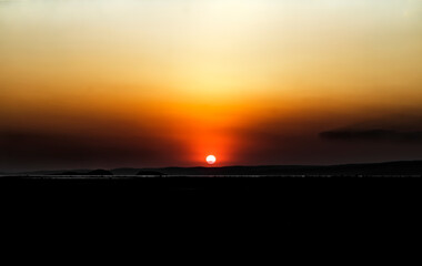 Dusk time, sun goes down as silent silhouette comes by