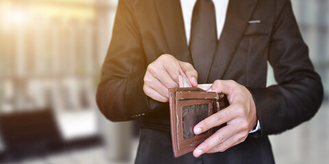 Businessman hand holding open old leather wallet with cash. business and finances concept.