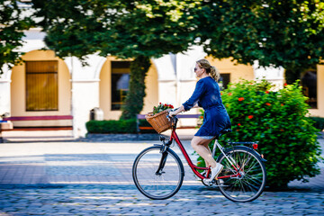 Fototapeta premium Urban biking - woman riding bike on city street 
