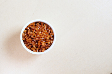 Bowl of Crystal Sugar isolated background, top view. Brown cane sugar.