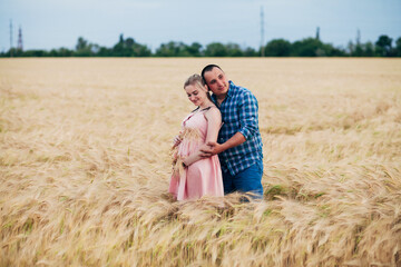Naklejka na ściany i meble future parents in a wheat field