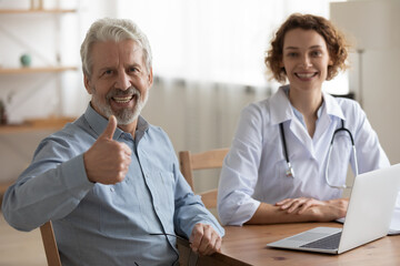 Smiling mature male patient show thumb up satisfied with good quality hospital medical service, portrait of happy senior man client recommend doctor or GP, recommendation, elderly healthcare concept