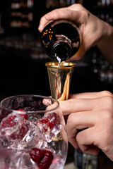 The bartender prepares a cocktail in the restaurant bar. The process of pouring alcohol into a glass.