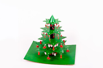 Step by step instruction how to make Christmas tree. Using glue we connect the star tiers decorated with pasta to each other with pieces of tube from paper towels and glue on a cardboard stand