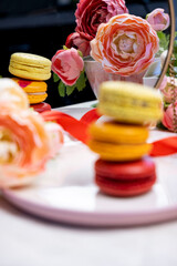 stack of colorful modern cakes cookies macaroons on plate  for celebration romantic party birthday, pion flowers, satin ribbon top view, many different types flavors of macarons dessert 